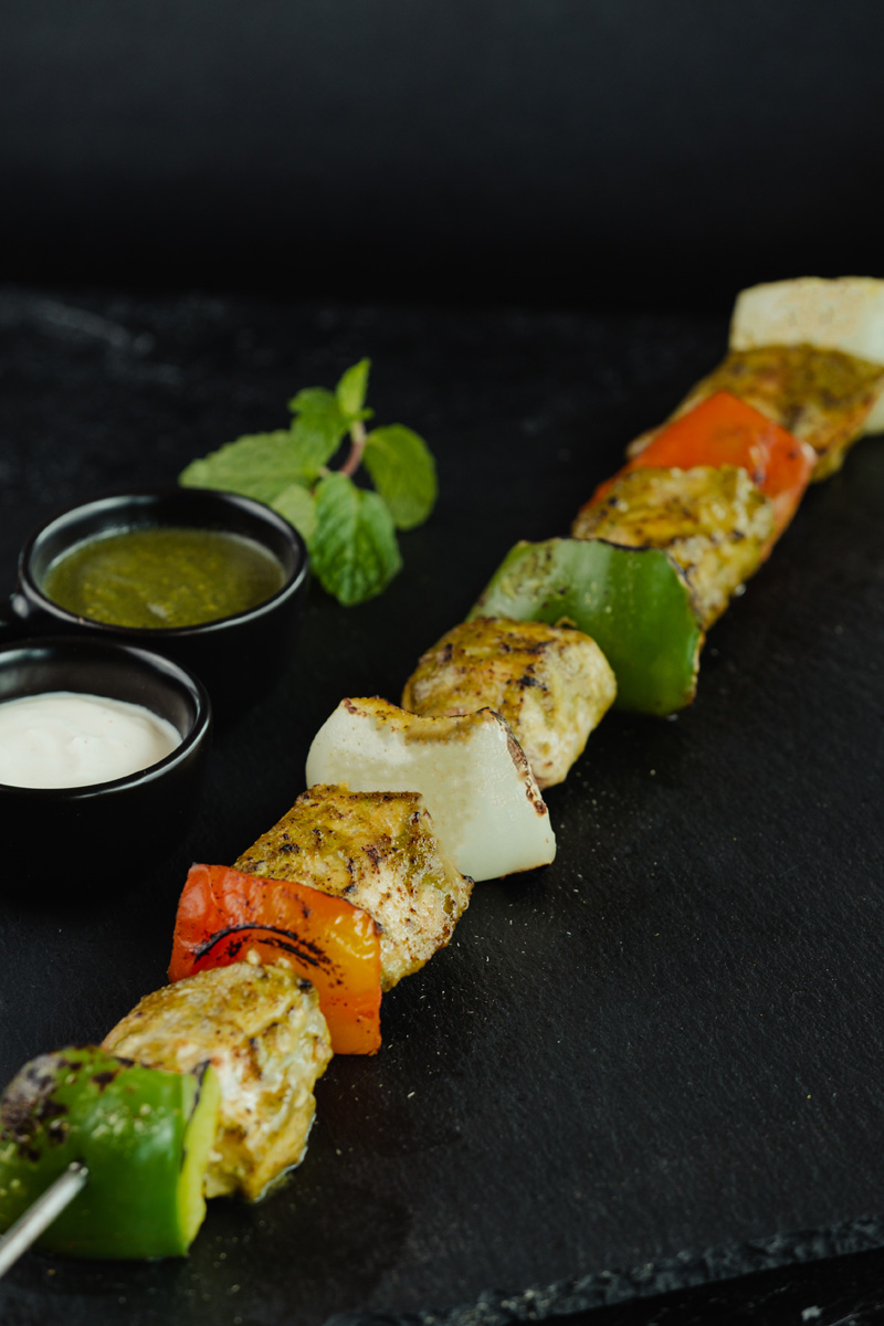 Macchi Harra Tikka Kebab on a black stone plate at Queen’s of India Nusa Dua Bali